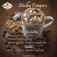 Javalicious Sticky Fingers coffee flavor profile with a cup of coffee and marshmallows on a wooden background.